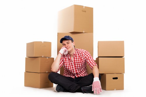 Removal crew handling boxes and furniture in a central London residential property