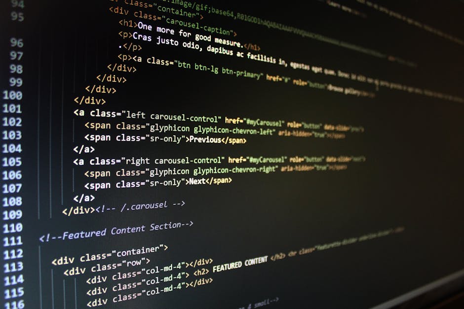 Close-up photograph of a computer screen displaying lines of programming code in various colors including green, purple, blue, orange, and white, set against a dark background. The code appears to be